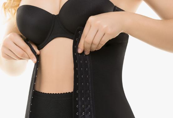 Woman putting on a waist trainer.